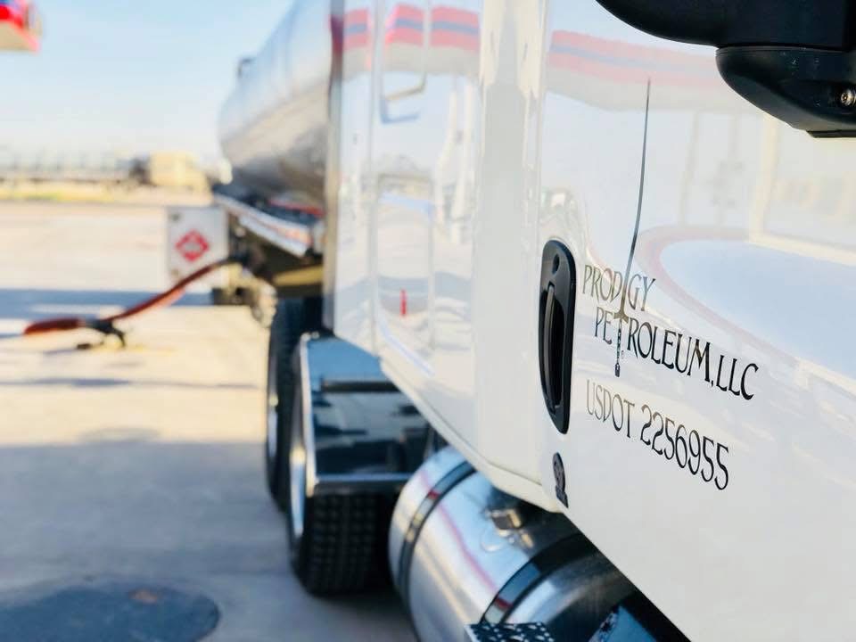 Prodigy Petroleum branding on the door of a white transport truck at a fuel delivery